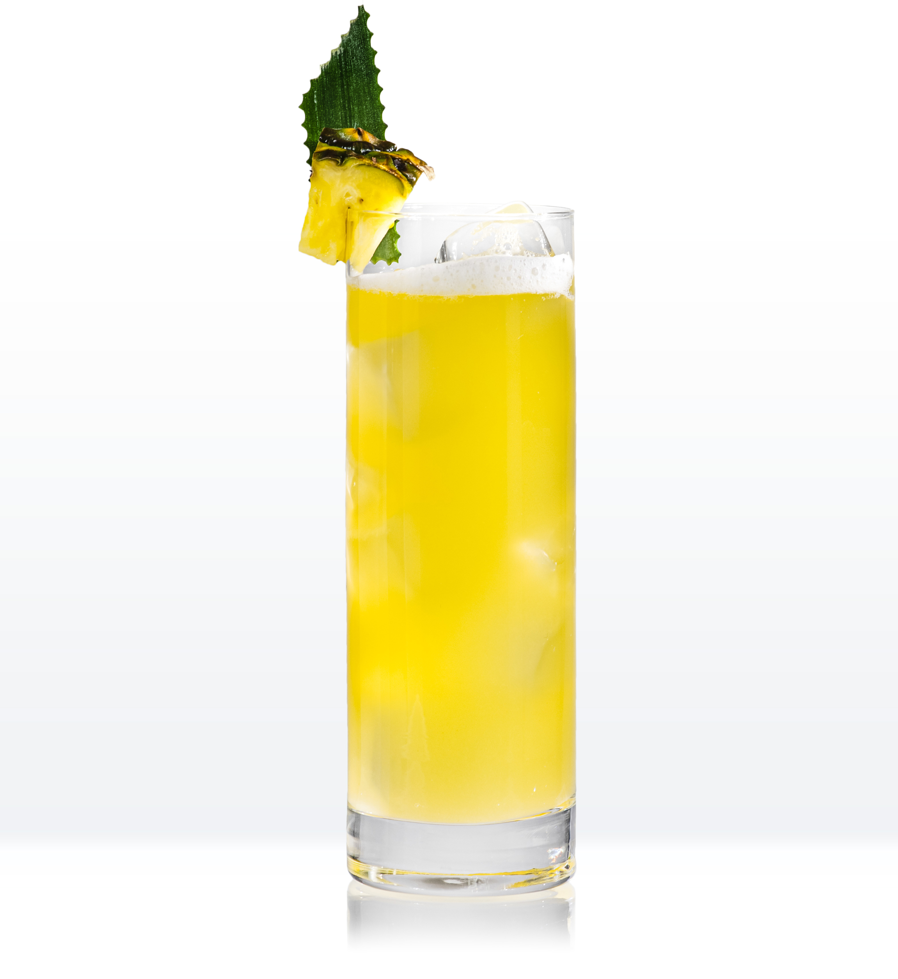 Yellow cocktail in highball glass garnished with pineapple chunk and pineapple leaf