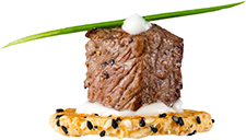 Seared filet mignon piece on Parmesan cookie with truffle aioli garnished with chive