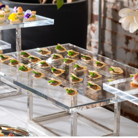 Event food station with mushroom hors d'oeuvres on acrylic and stainless steel elevations
